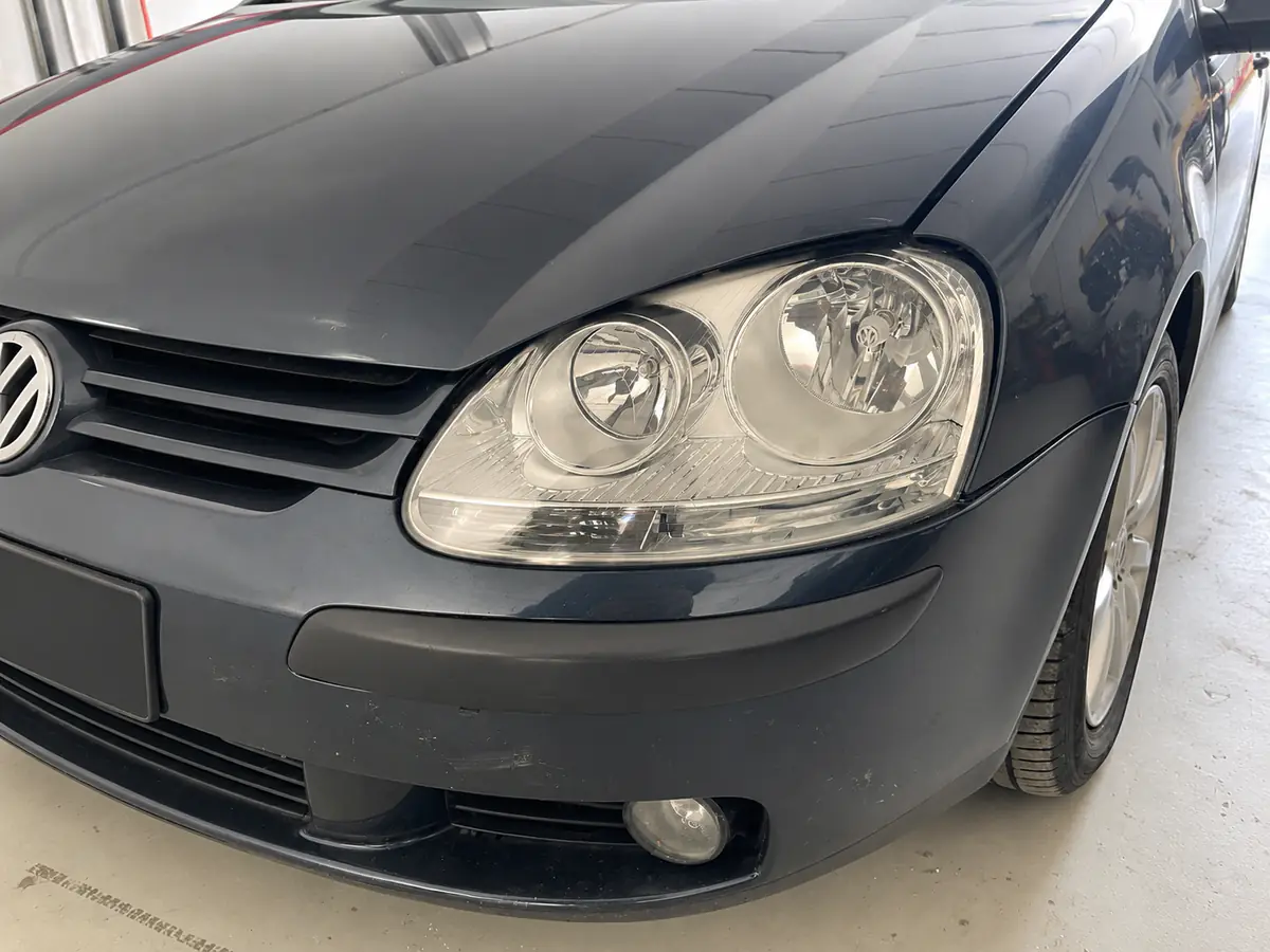 Faro di una Golf nera dopo il ripristino, trasparente e lucido