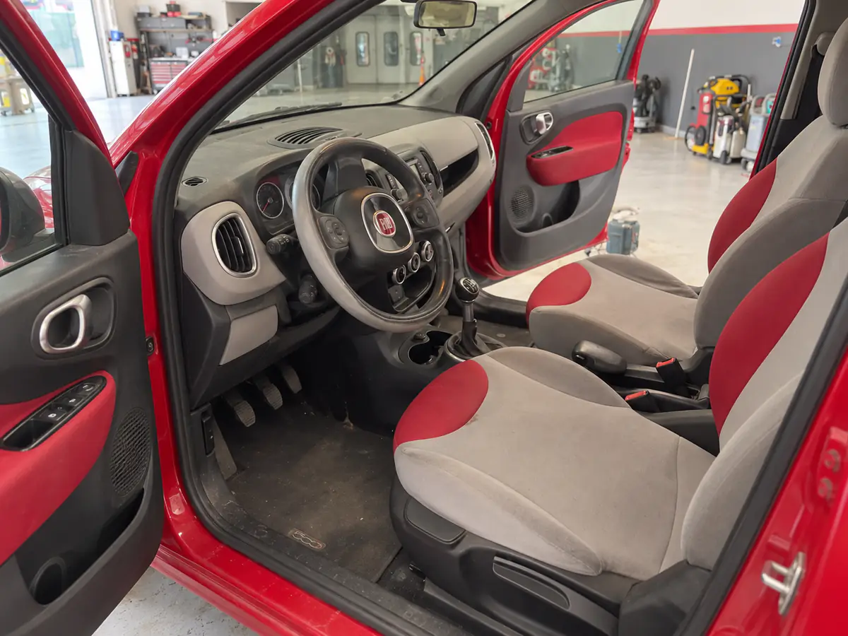 Interni di una Fiat rossa prima della pulizia