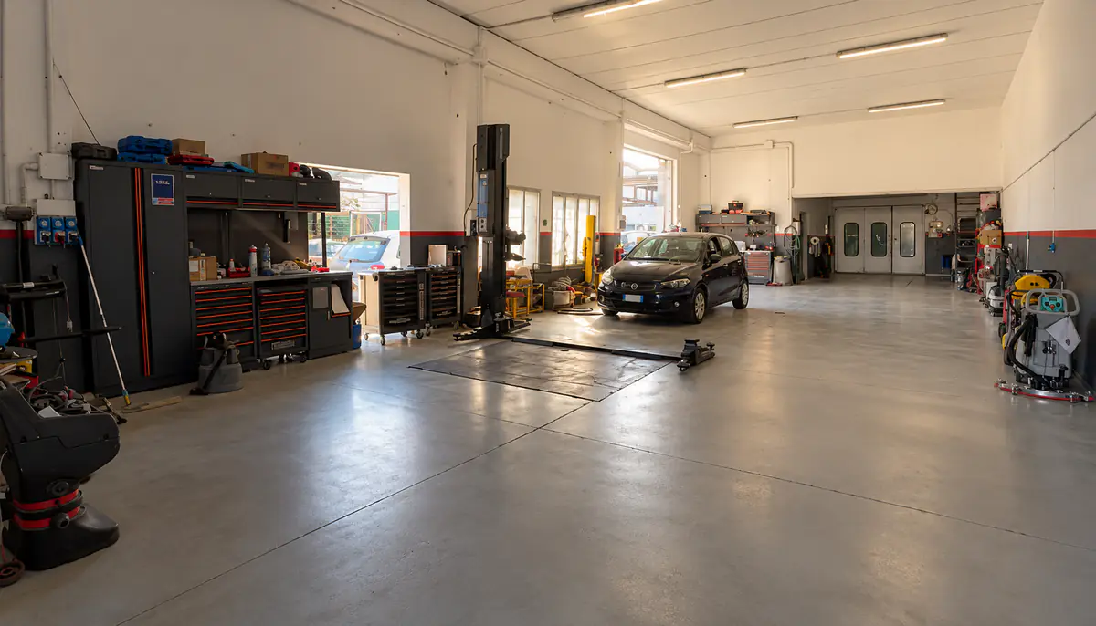 L'interno dell'officina Gasi: ponte sollevatore, banchi attrezzi e un'auto in fondo al capannone